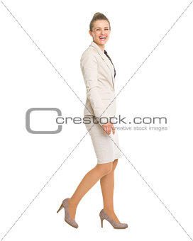 Full length portrait of happy business woman going sideways