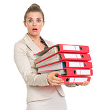Surprised business woman holding stack of folders