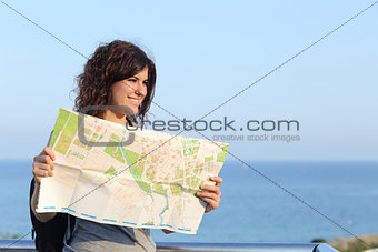 Beautiful tourist woman on vacation with a city map