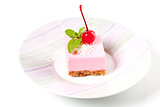 Pink cheesecake with maraschino cherry and mint