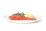 Piece of salmon with lemon and dill on plate