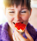  Woman eating the sandwich with red caviar 