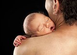 Newborn boy sleeping on his dad's shoulder