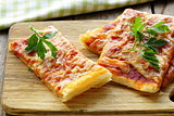 pizza of puff pastry with tomato sauce and parsley