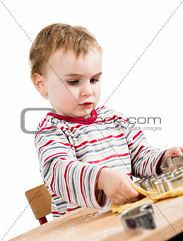 young child isolated in white background baking cookies
