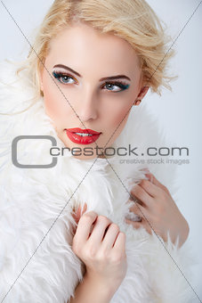 Stylish blonde woman posing in white fur