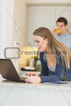 Woman talking via Webcam with man drinking orange juice