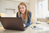 Woman laughing at laptop