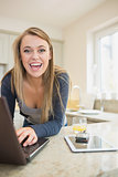 Laughing woman at laptop with smart phone and tablet