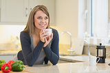 Woman in the kitchen drinking hot beverage