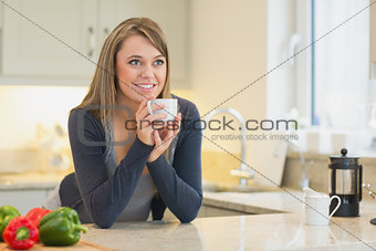 Woman in the kitchen drinking hot beverage