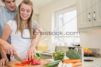 Woman and man cutting peppers