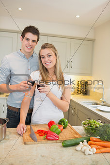 Man and woman cooking and clinking wine glasses