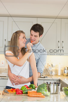 Woman feeding man with a pepper