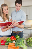 Couple reading cookbook together