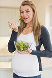 Pregnant woman eating fresh salad bowl