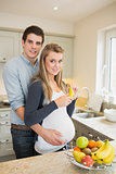 Pregnant woman holding banana with partner