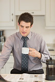 Man turning the page while drinking coffee