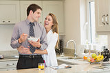 Woman hugging her husband while eating cereal