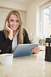 Woman phoning and holding a tablet