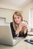 Woman drinking a coffee while working with multimedia