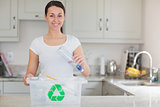 Woman throwing bottle into recycling bin