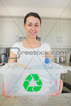 Woman holding full recycling bin
