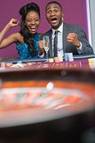 Couple sitting cheering at roulette wheel