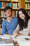 Two happy students in a library