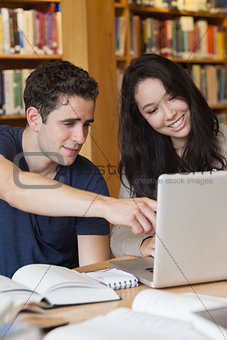 Two students learning on the laptop in a library