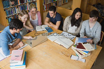 Students learning with laptop and tablet  in a library