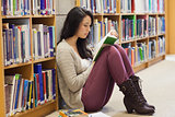 Student leaning against a shelf in a library