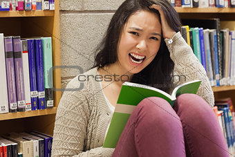 Stressed student reading in a library