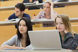 Students in a lecture hall using a laptop