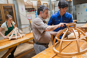 Teacher helping a student in a woodwork class