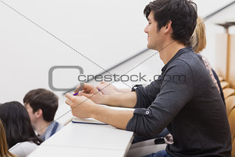 Student sitting in a lecture hall and listening the teacher
