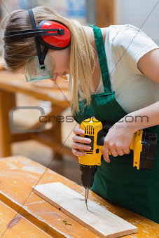 Student in a woodwork class using a drill