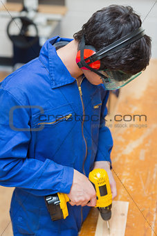 Student at a workbench using the drill
