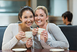 Two smiling students in college coffee shop