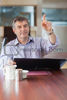 Man in a coffee shop calling a waiter