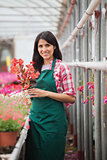 Garden center employee standing and holding flower pot