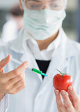 Woman injecting a tomato