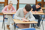 Writing students at  desks in a classroom