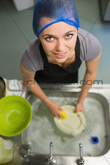Smiling woman looking up from washing up