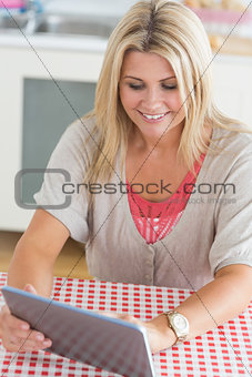 Laughing young woman working on tablet