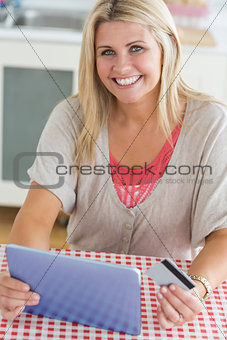Smiling woman shopping online with her digital tablet