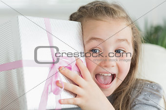Surprised girl shaking a present