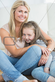 Mother and daughter hugging in living room