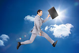 Happy businessman jumping with his briefcase