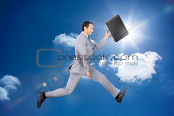 Happy businessman jumping with his briefcase